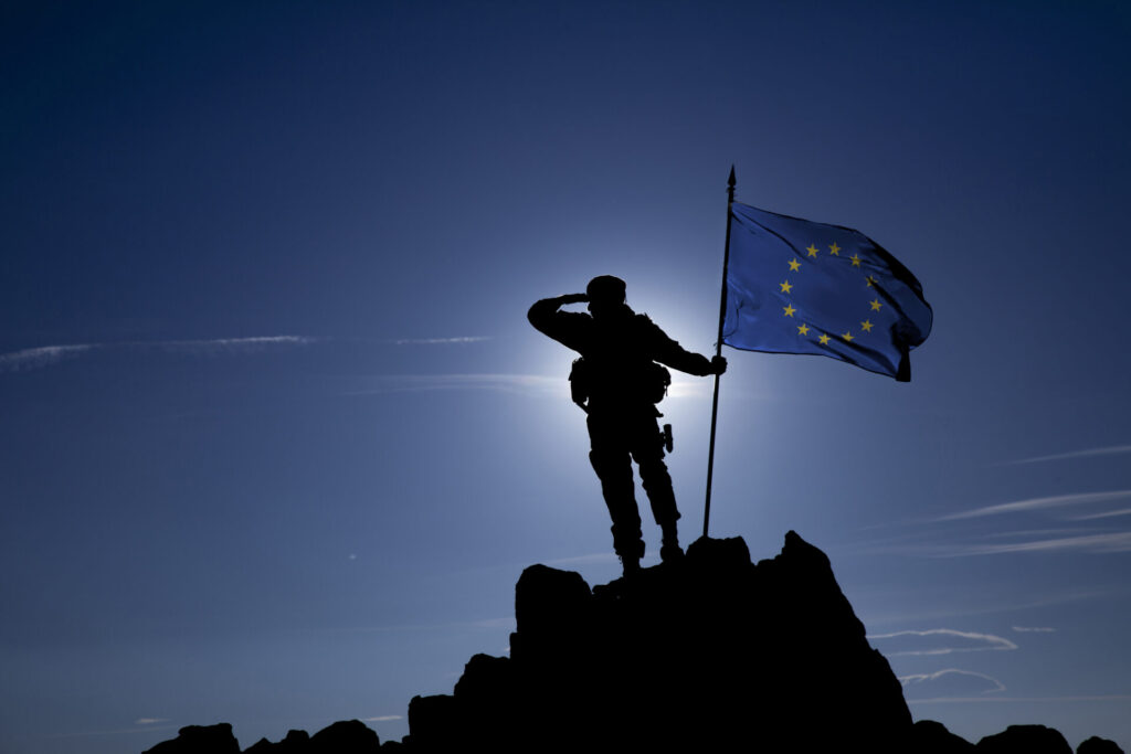 Soldier on top of the mountain with a flag of the European Union