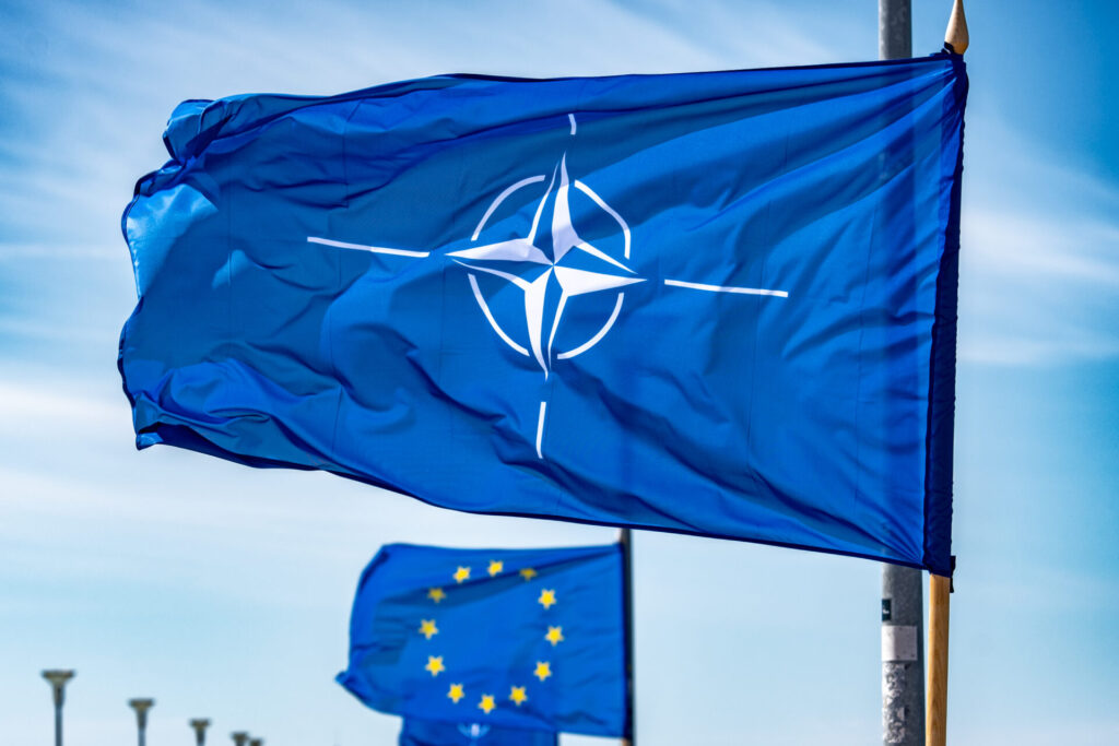 Vilnius, Lithuania - February 25 2025: NATO flag waiving on a flagpole with European Union flag behind