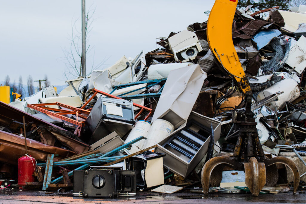 Powerful mechanical grabbing arm is the force that moves old scrap metal and used household appliances in a scrap yard.